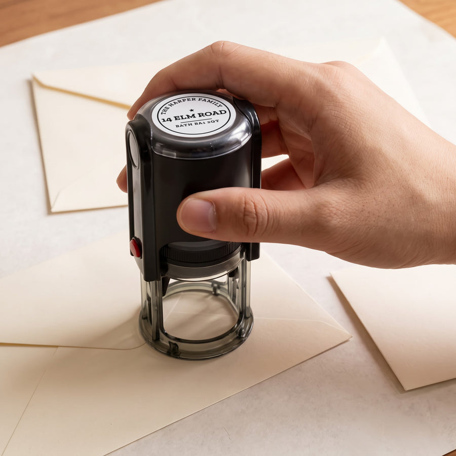 Hand pressing a personalised self-inking stamp onto an envelope