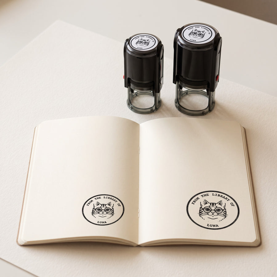 40 mm and 50 mm personalised self-inking stamps with their prints in an open book