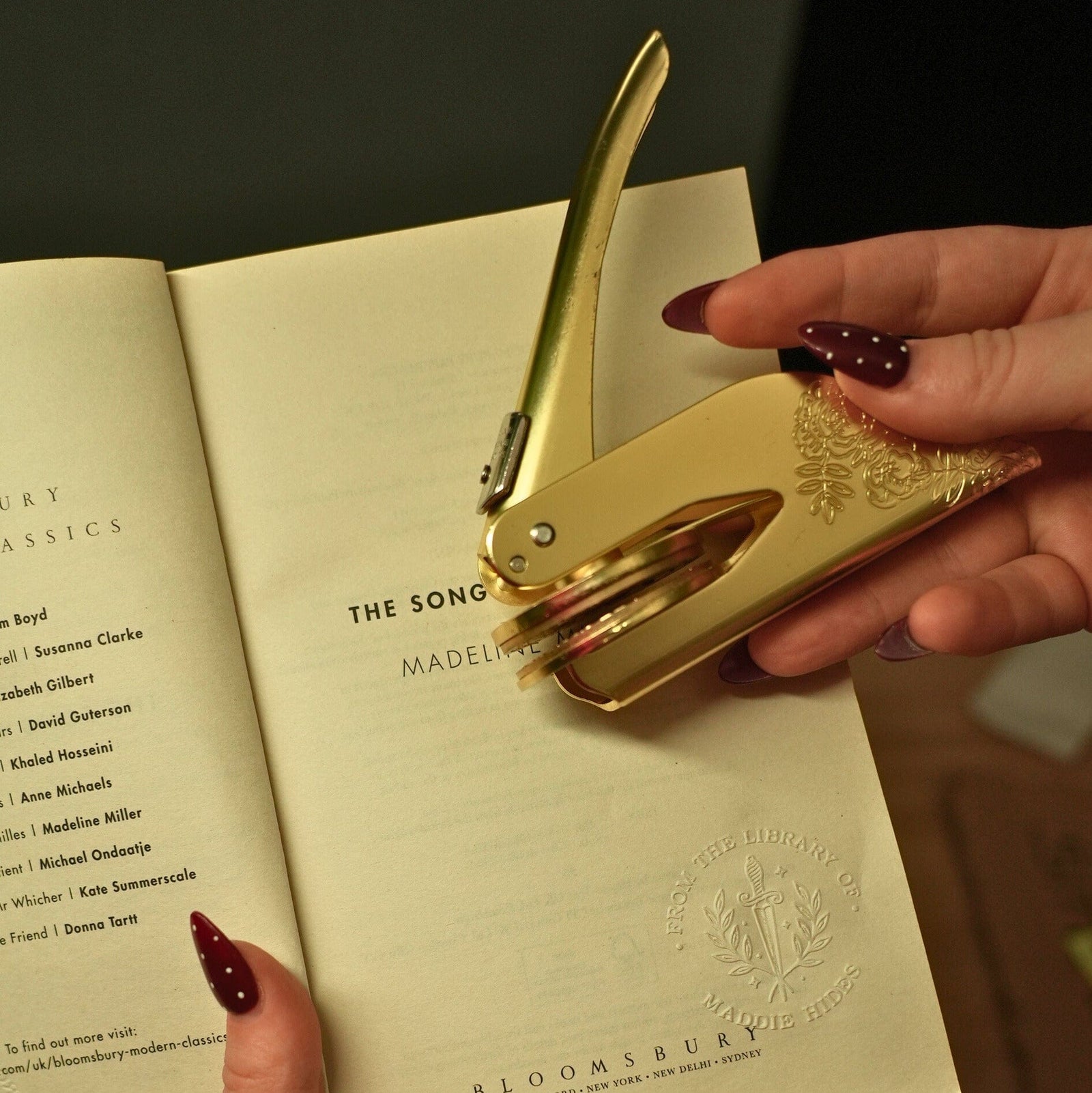 Pressing a personalised gold book embosser into a title page