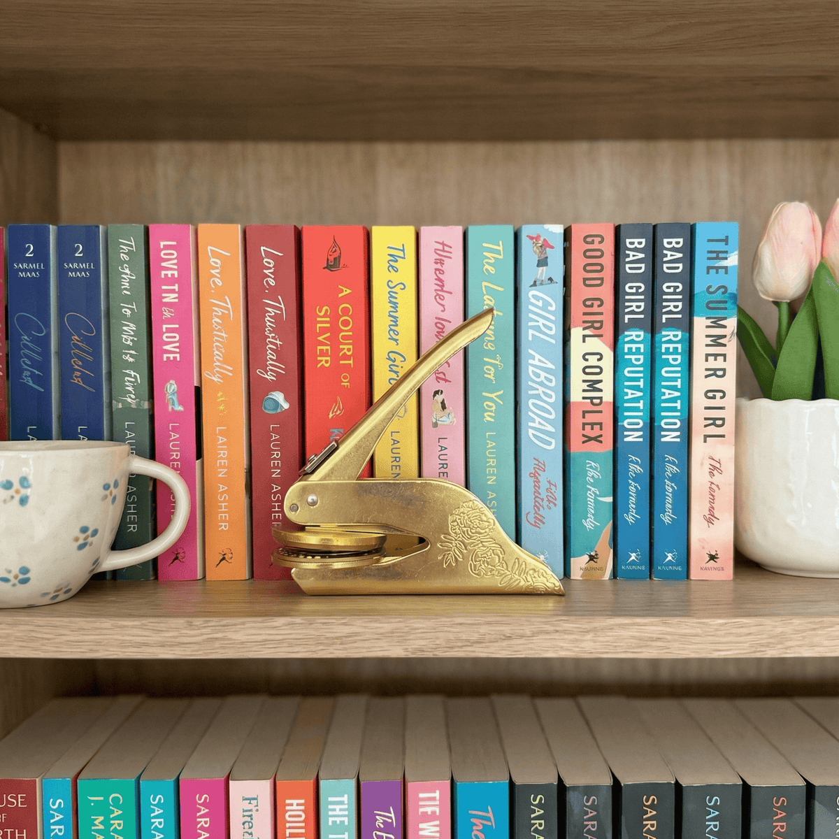 A gold embosser on a shelf of colourful books