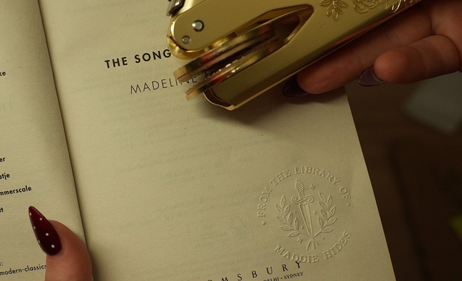 A book embosser above a crisp, evenly pressed From the Library of impression on a title page