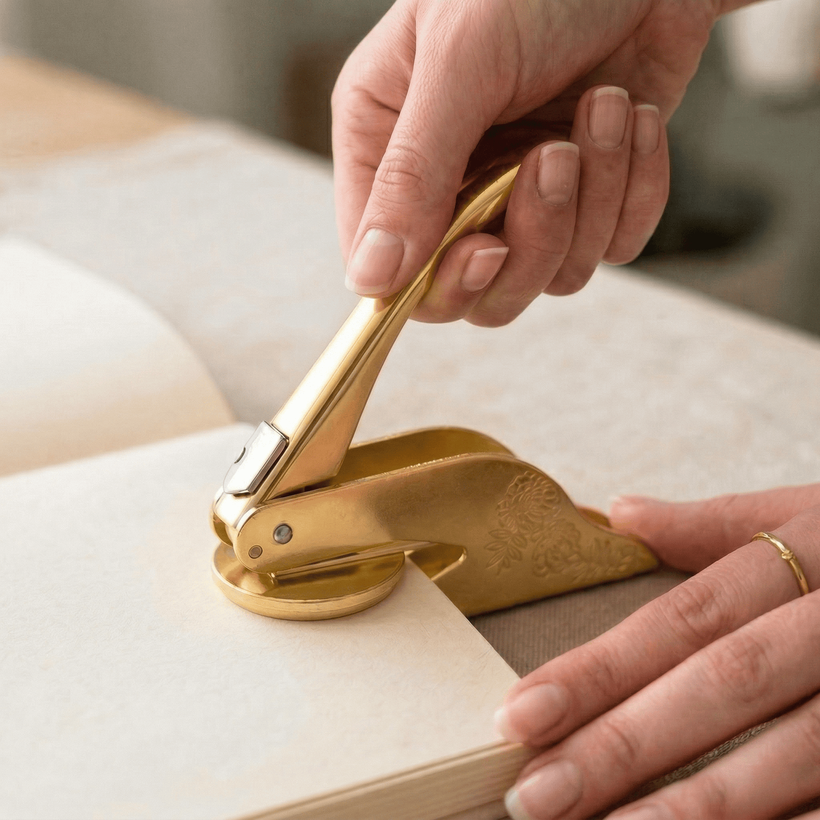 A solid brass embosser resting on a cream book.