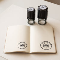 40 mm and 50 mm personalised self-inking stamps with their prints in an open book