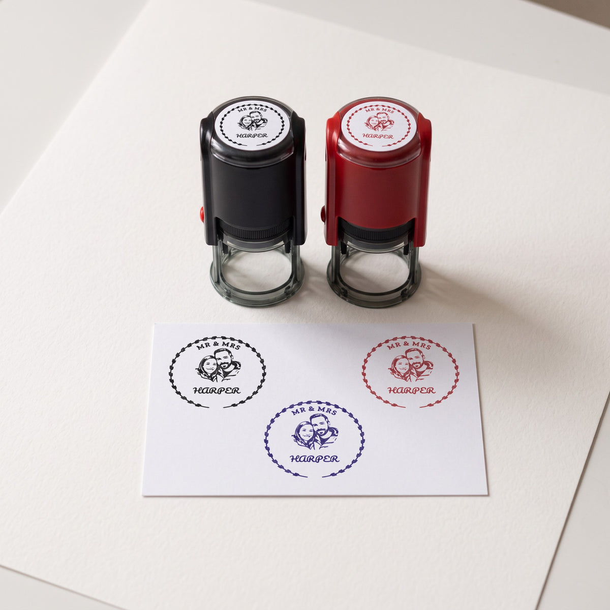 Sello personalizado con el retrato de una pareja, estampado en tinta negra, azul y roja, con las carcasas negra y roja