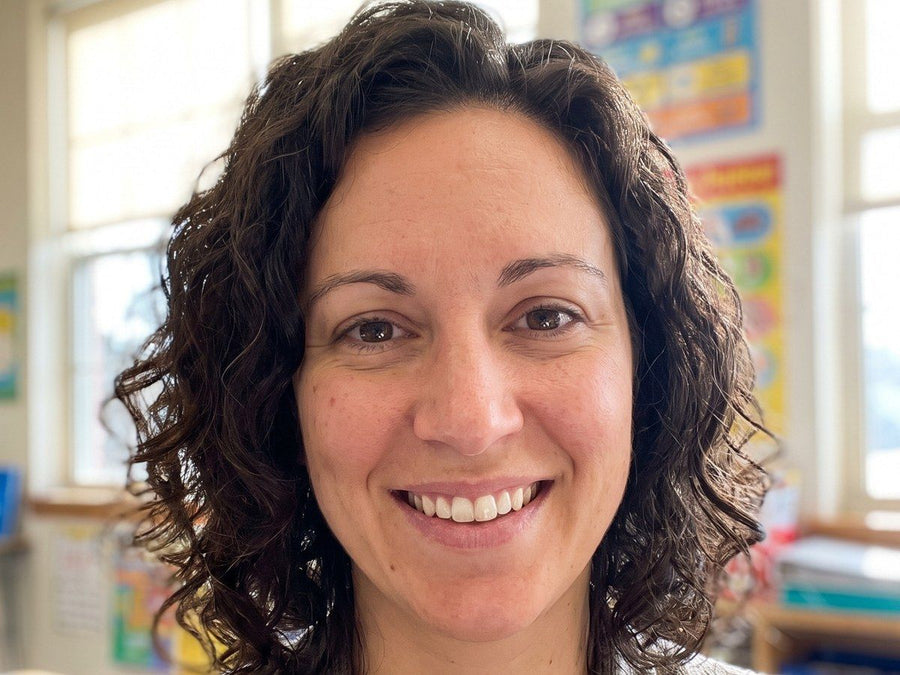 A phone photo of a smiling woman with curly hair